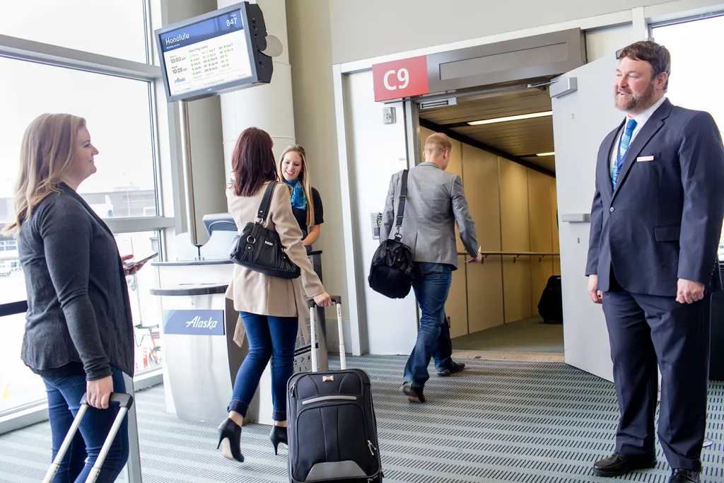 A man and woman walk in an airport, making their way to the United Airlines boarding group for departure.